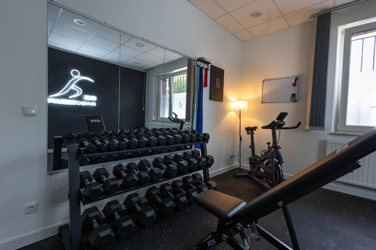 Modernes Home Gym mit Kurzhanteln und stationärem Fahrrad