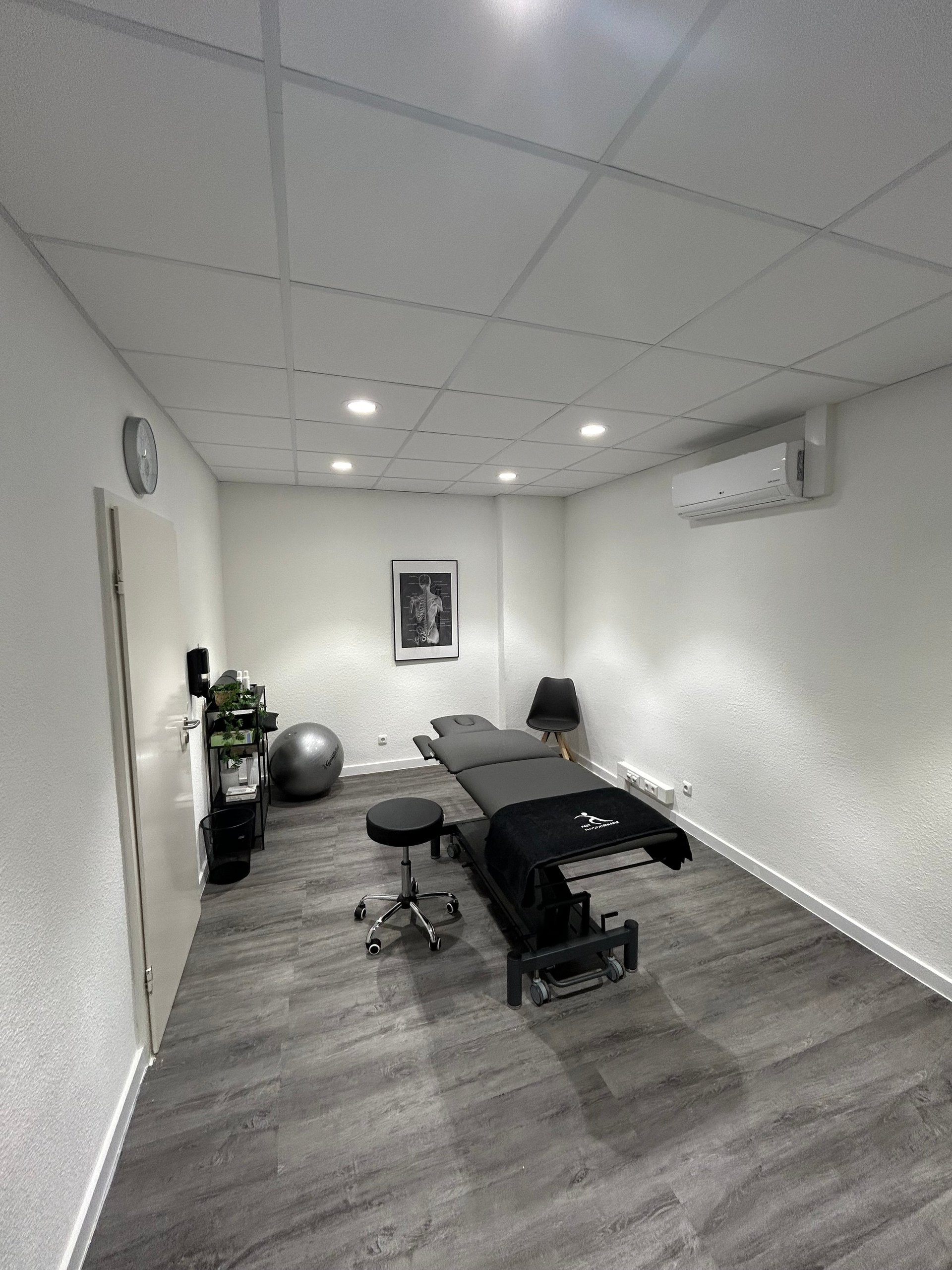 Modern physical therapy clinic room with treatment bed and exercise equipment